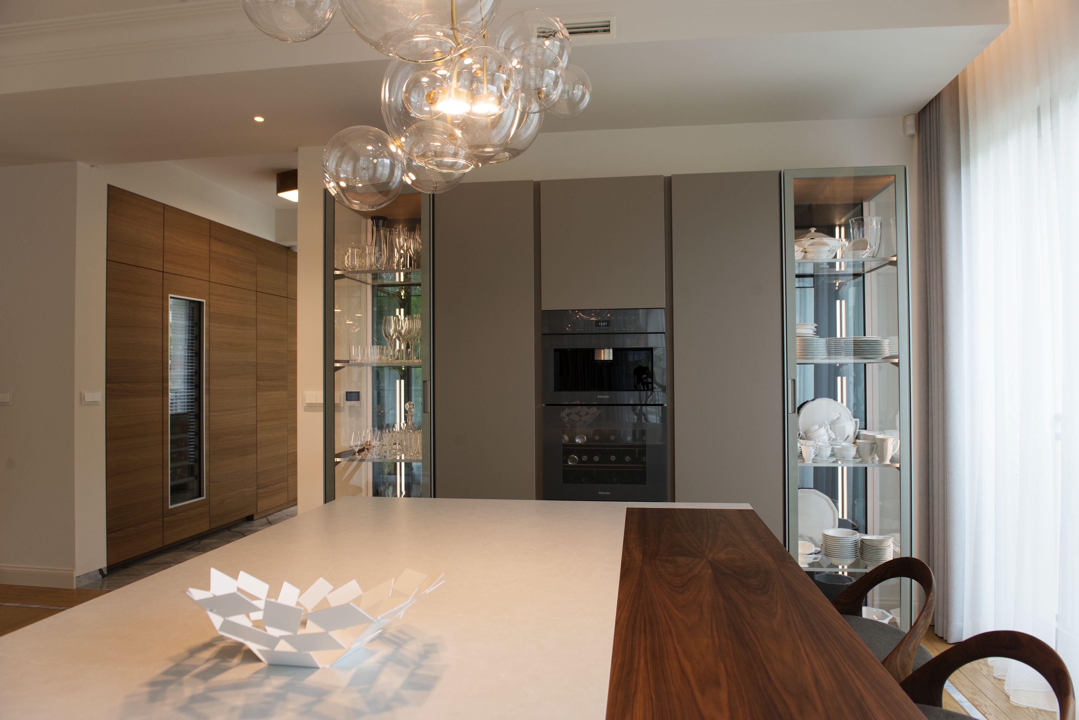 Bardzo pojemna zabudowa z podświetlonymi witrynami po bokach. Nieoczywisty odcień brązu, nadaje jej unikalny charakter.